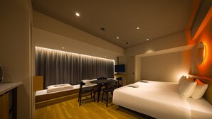 A modern hotel room with a large bed, a desk, and a chair. - &Here SHINJUKU (Tokyo)