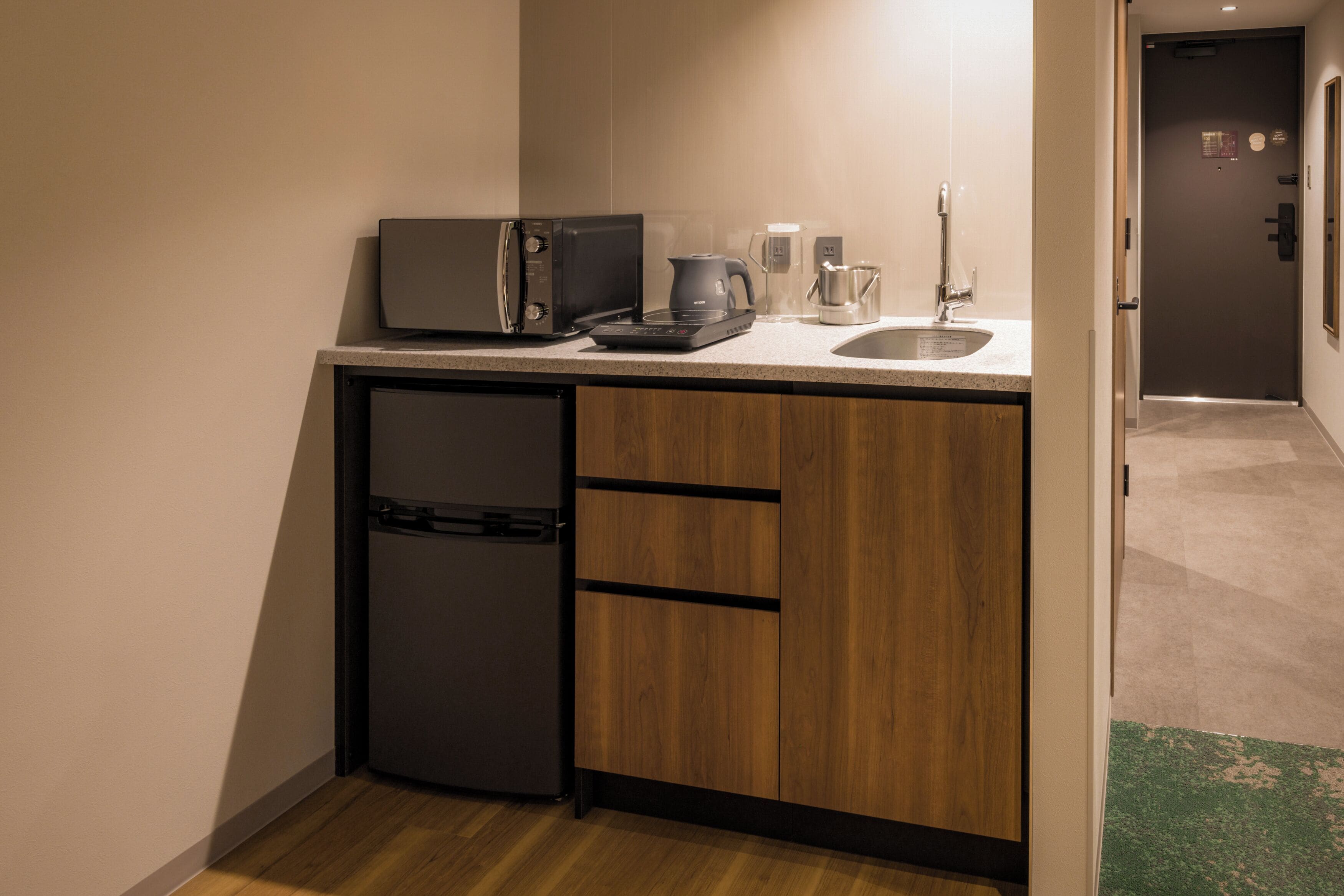 A compact kitchen with a microwave, coffee maker, and a small refrigerator.