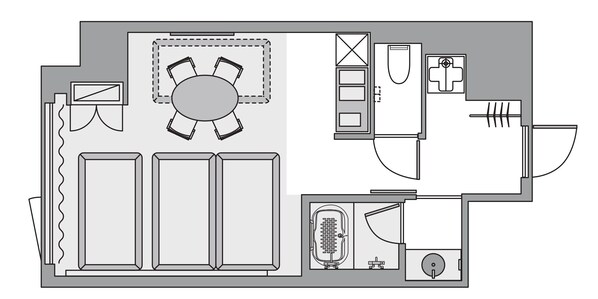 Un plan d’étage comprenant un coin repas, deux chambres, une salle de bain et une cuisine.