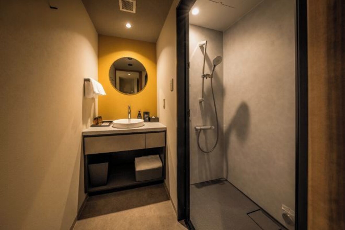 Ein modernes Badezimmer mit Waschbecken, Spiegel und Dusche.