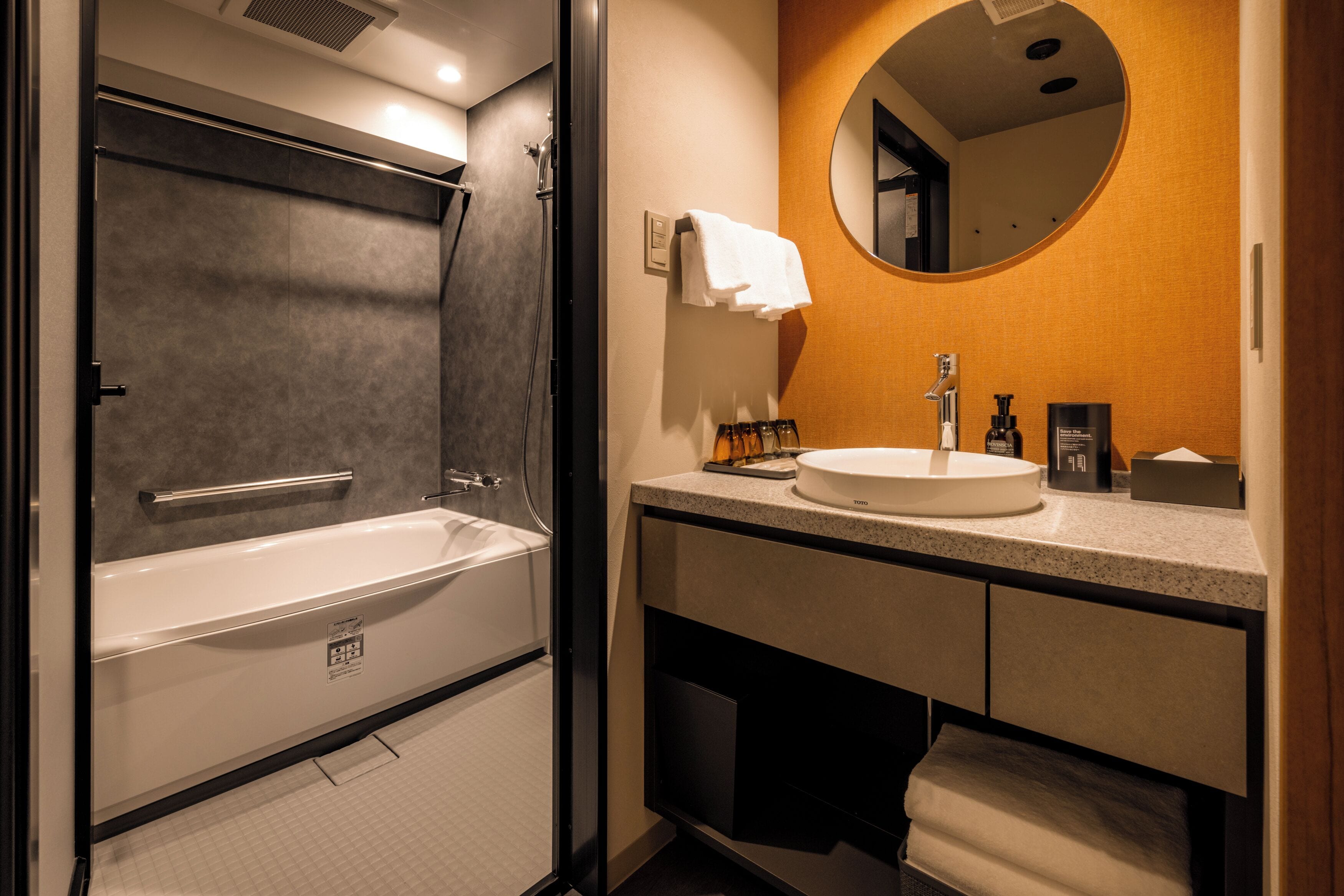 A modern bathroom with a bathtub, a sink, and a mirror.