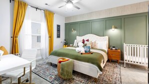 A bedroom with a bed, bedside tables, a chair, a desk, and a ceiling fan. - Regal Hideaway | Pool Near Lackland + Med Ctr Gym! (San Antonio)