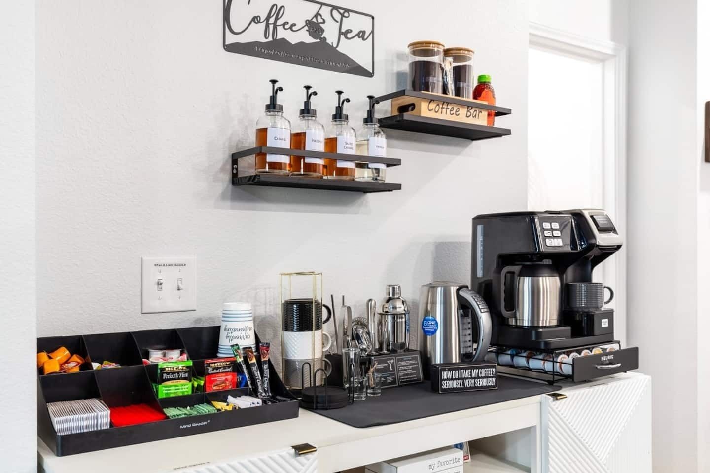 A coffee bar with a coffee machine, dispensers, and a sign that reads "How do I take my coffee? Seriously, very seriously."