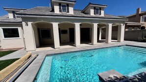 Una moderna casa con piscina, veranda coperta e design a due piani.