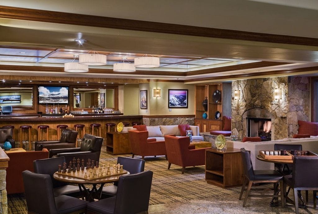 Un hall d’entrée spacieux avec un bar, des sièges confortables, une cheminée et un grand écran.
