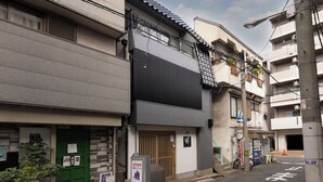 A traditional Japanese building with a green door, a small shop, and a signboard. - Whitedragon60 (Osaka)
