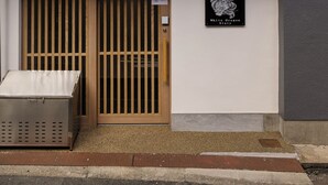 A building with a black and white facade, a wooden door, and a sign that reads "White Dragon Sixty Six." - Whitedragon60 (Osaka)