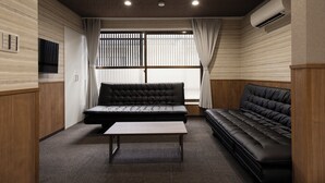 A modern room with a sofa, a table, and a window with blinds. - Whitedragon60 (Osaka)