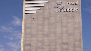 Un edificio de hotel alto con diseño moderno, que presenta un llamativo letrero 'Hotel Lepeble' en la fachada.