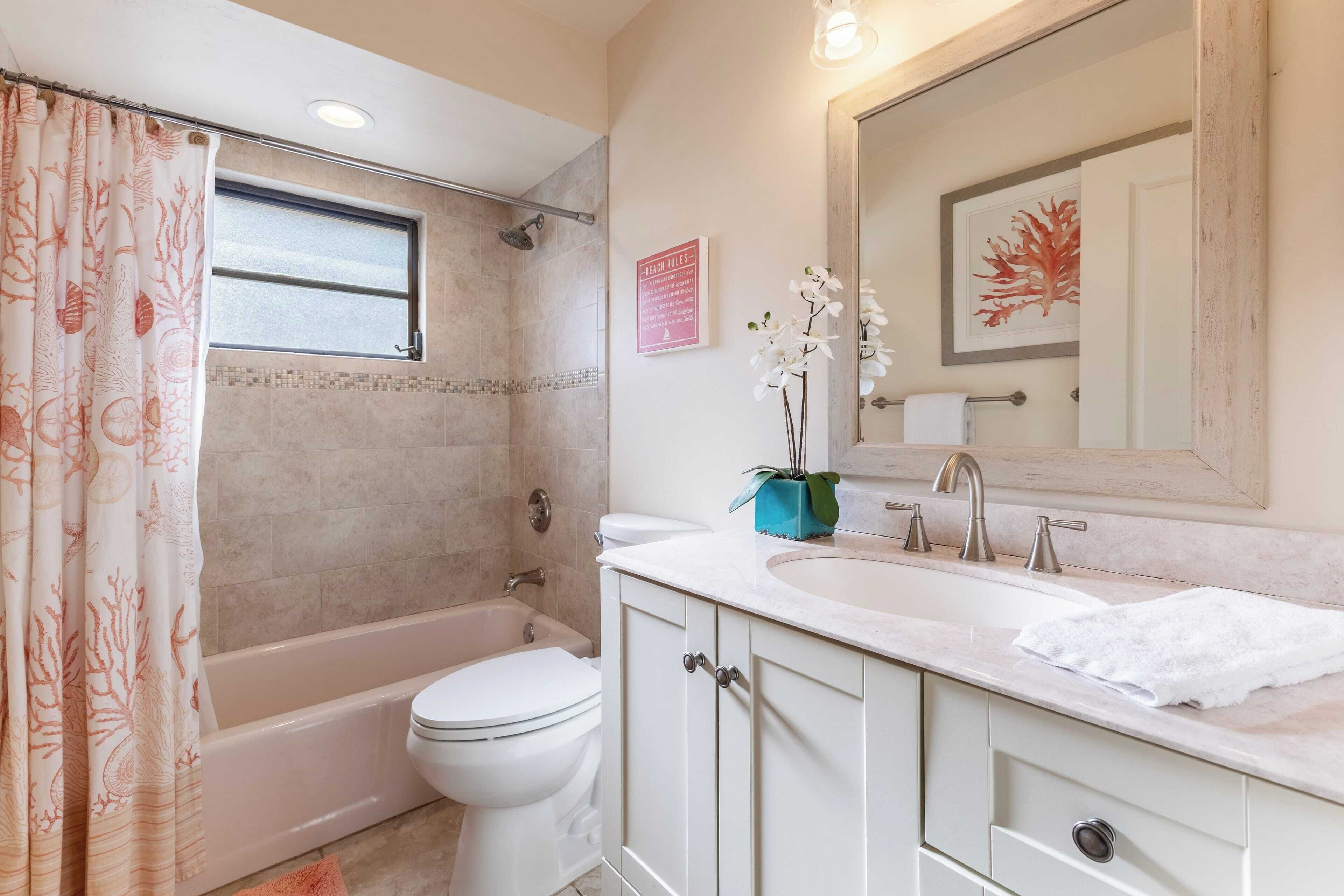 A bathroom with a bathtub, toilet, and sink.