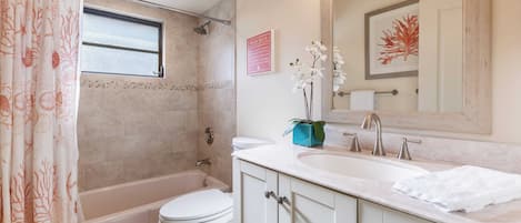 A bathroom with a bathtub, toilet, and sink.