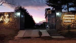 A gated entrance with illuminated signs for 'Aural' and 'Alojamiento Receptiones Eventos'.