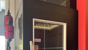 Una habitación moderna con puerta de vidrio, un letrero que dice 'No fumar', un letrero que dice 'Tirar' y un panel de control.