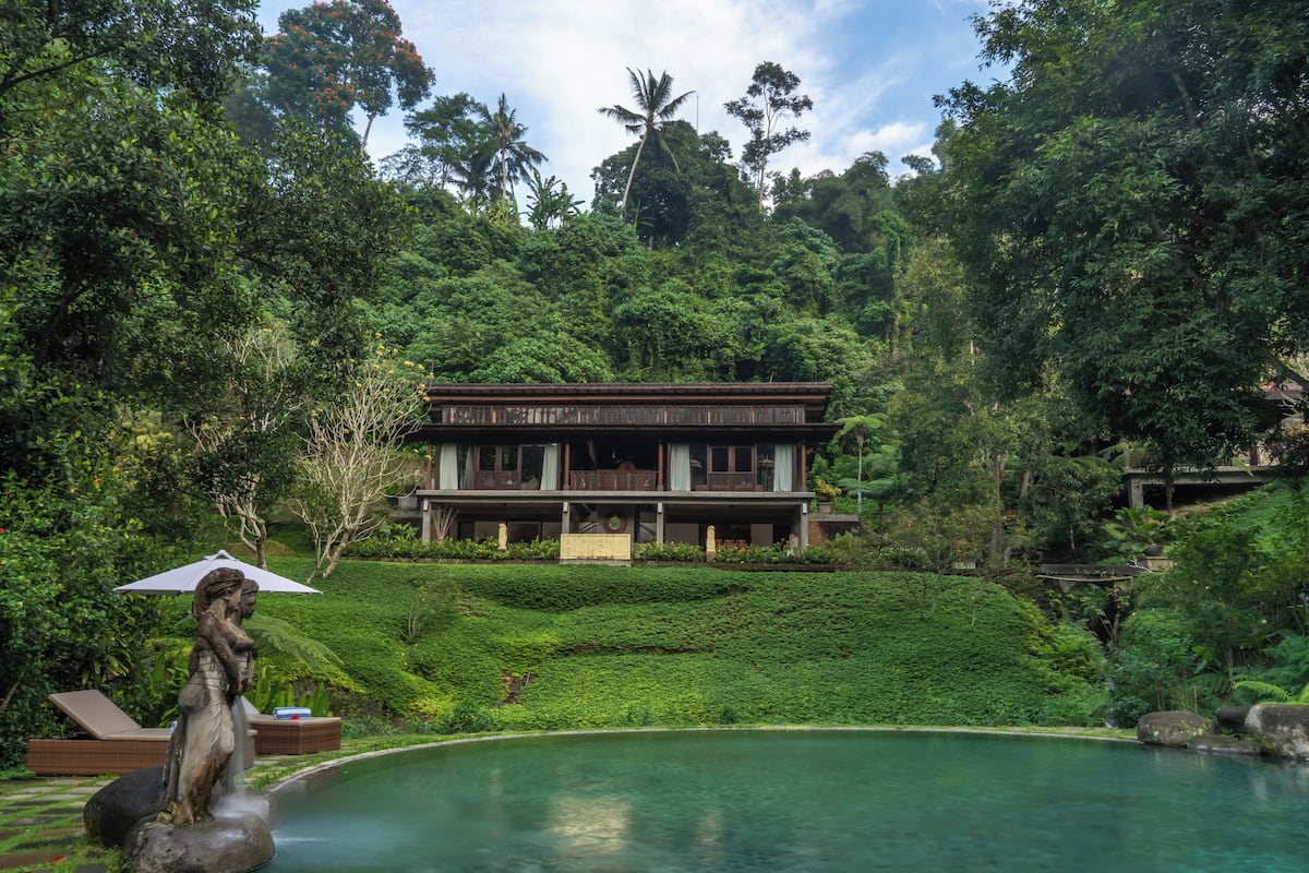 A large house with a pool and lush greenery.