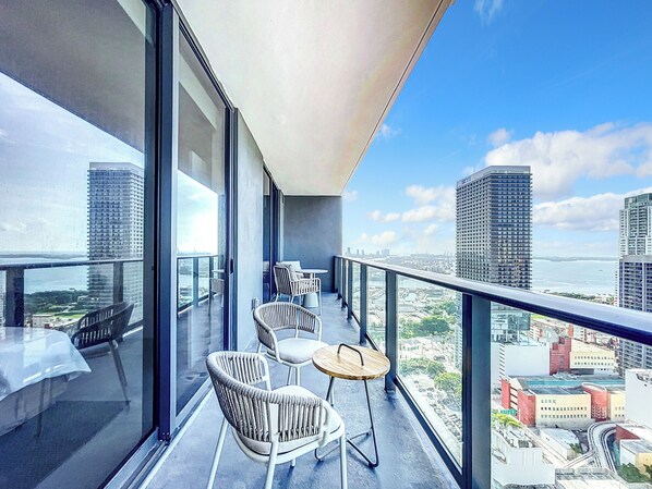 Un balcon avec vue sur la ville, comprenant une table et des chaises.