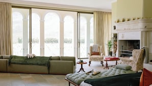 A spacious living room with a sofa, a bed, and a fireplace. - Manor House at La Roche Estate - Franschhoek (Franschhoek)
