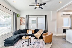 Una sala moderna con un sofá modular, una mesa de centro y un sillón.