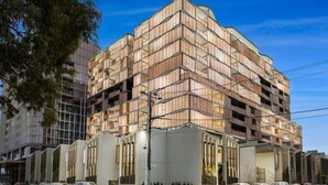 A multi-story building with a modern architectural design, featuring a series of balconies and large windows. - luxury apartment with water views. Walking distance from beach (Port Melbourne)