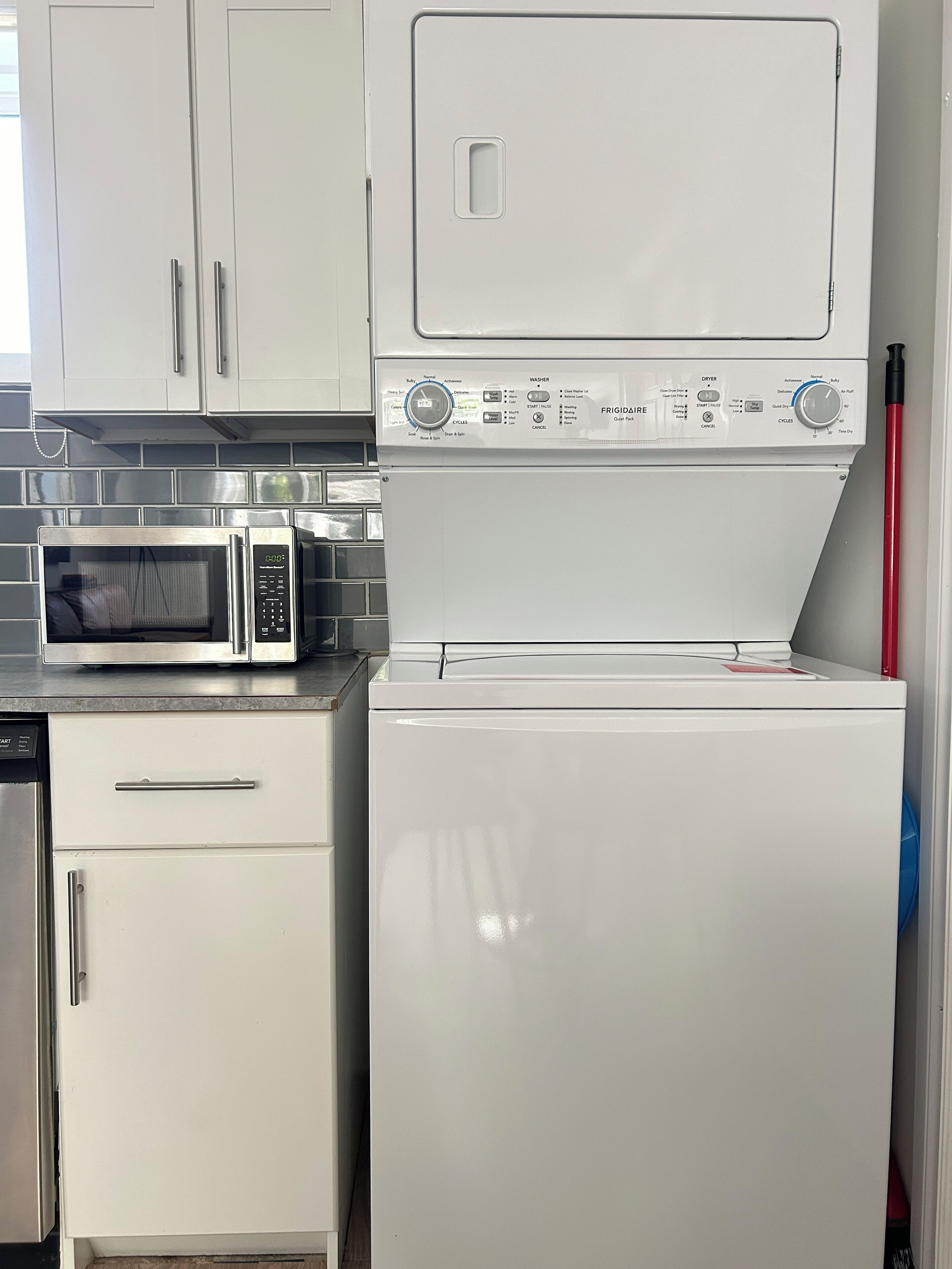 Uma cozinha compacta com micro-ondas, máquina de lavar louça e frigorífico.