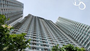 Un edificio de gran altura con un diseño arquitectónico moderno, que presenta una cuadrícula de ventanas y balcones.
