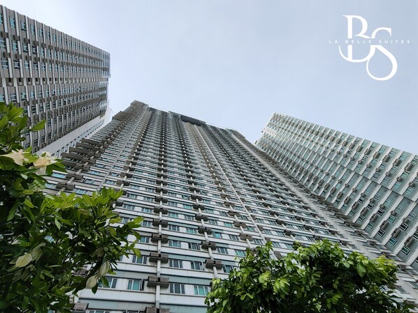 A high-rise building with a modern architectural design, featuring a grid of windows and balconies.