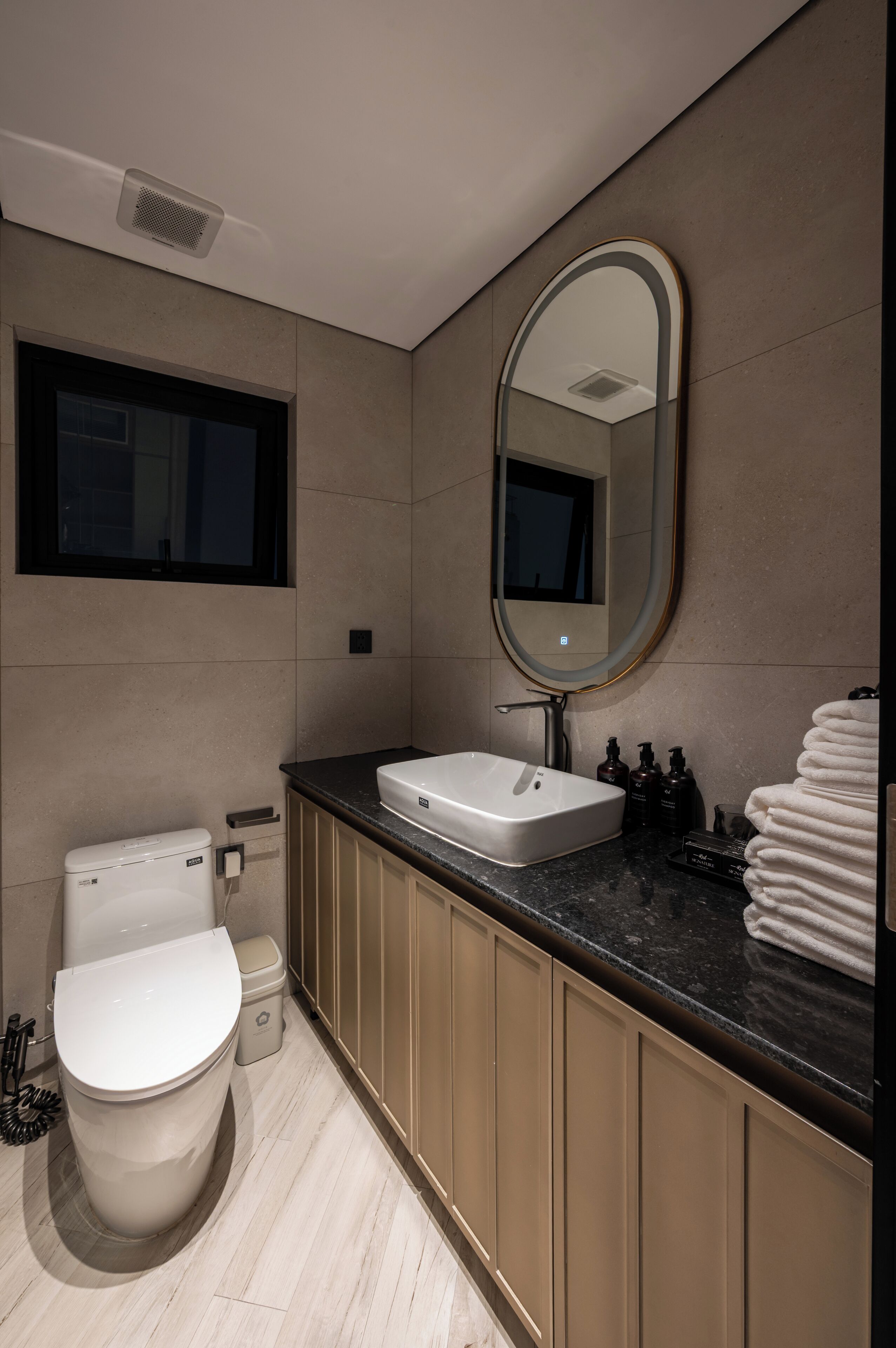Ein modernes Badezimmer mit Toilette, Waschbecken und Spiegel.