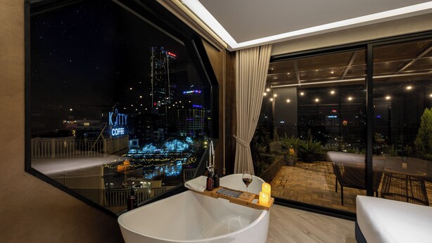 A modern bathroom with a large bathtub, a glass-enclosed shower, and a city view. - iRest Signature Ba Dinh Lakeside (Hanoi)