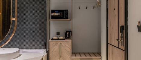 A modern bathroom with a large mirror, a sink, a shower area, and a wooden cabinet.