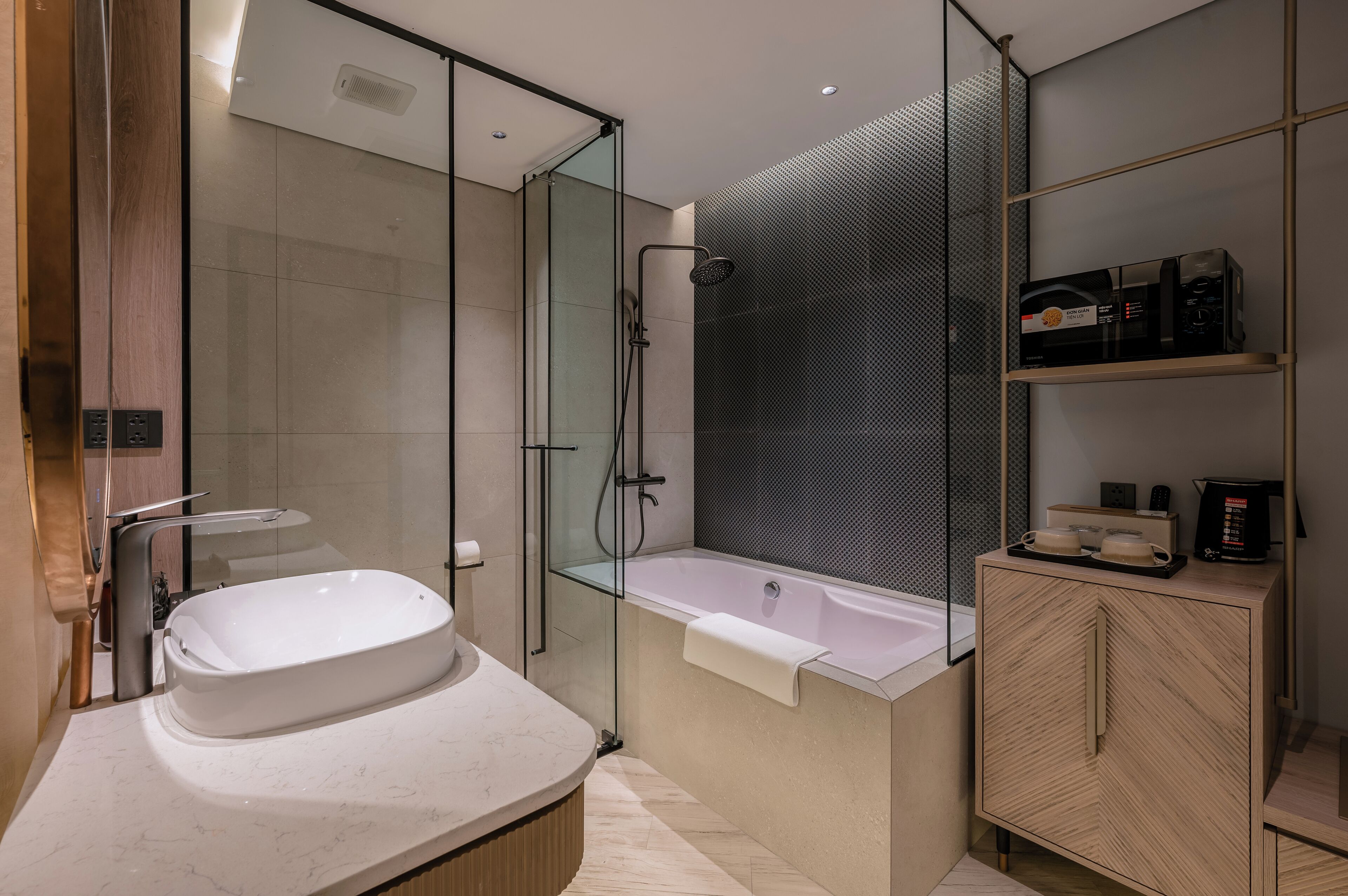 A modern bathroom with a freestanding bathtub, a glass-enclosed shower, and a wooden cabinet with toiletries.