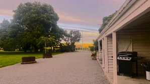A gravel path leading to a building with a barbecue area. - Taringatura Backpackers (Dipton West)