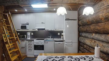 A compact kitchen with a wooden ceiling, a microwave, a stove, and a sink.