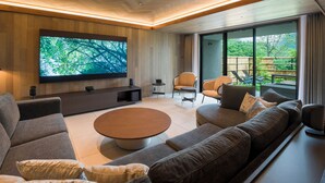 A modern living room with a large flat-screen TV, comfortable seating, and a view of the outdoors. - Rakuten STAY TERRACE Hakone Kowakudani (Hakone)