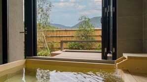 A hot tub with a wooden deck and a view of a bamboo fence and mountains. - Rakuten STAY TERRACE Hakone Kowakudani (Hakone)