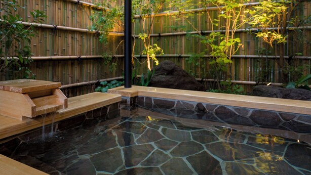 A hot spring area with stone and wooden steps leading into the water, surrounded by bamboo and greenery. - Rakuten STAY TERRACE Hakone Kowakudani (Hakone)