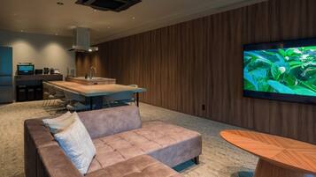 A modern living room with a sofa, a wooden coffee table, and a TV mounted on the wall.