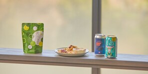 A snack pack, a plate with cookies and nuts, and two cans on a windowsill. - Rakuten STAY TERRACE Hakone Kowakudani (Hakone)