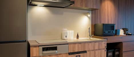 A modern kitchen with a built-in oven, a stainless steel sink, and a microwave.