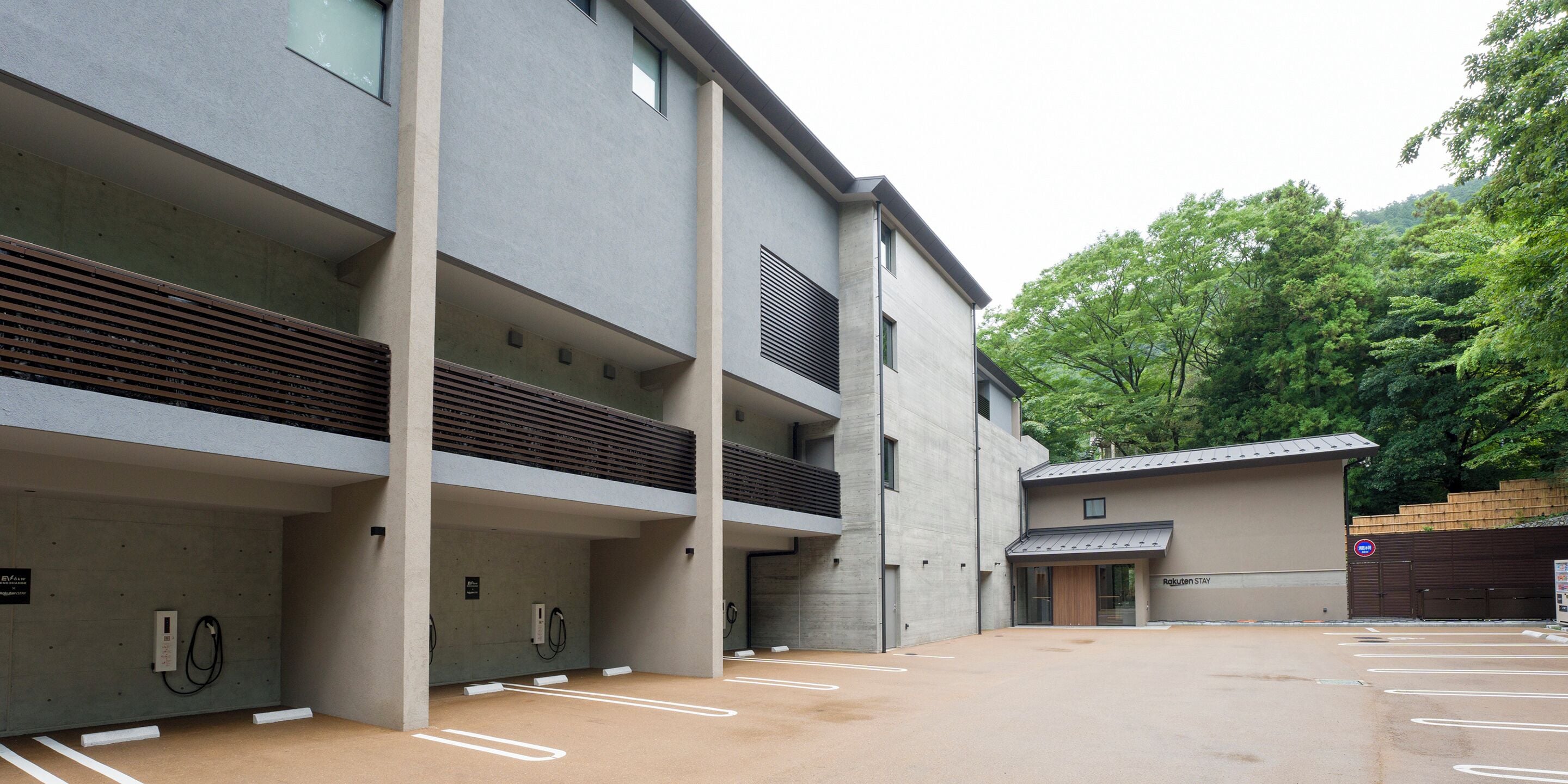 A modern building with multiple parking spaces and a covered area.