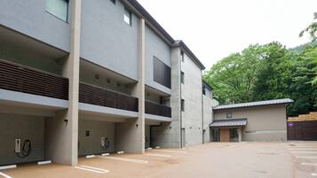 A modern building with multiple parking spaces and a covered area.