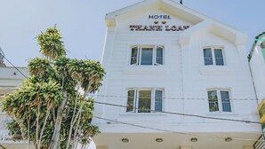 A two-story building with a sign reading "HOTEL THEANH LOAN".