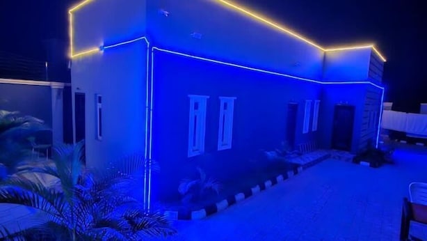 A modern building with a flat roof and a blue-lit exterior.