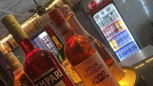 A bar area with bottles of liquor, including brands like Johnnie Walker and Four Coast Rose, on a Guinness branded coaster.