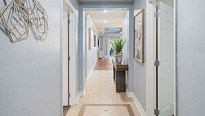 A hallway with light blue walls, white doors, and a tiled floor. - Villas South Meadow: Free Water Park, Golf View, Pool, Near Disney (Kissimmee)