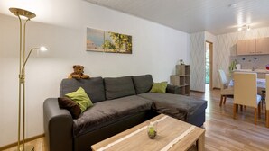 Una sala de estar moderna con un sofá, una mesa de centro, una lámpara de pie y un cuadro en la pared.