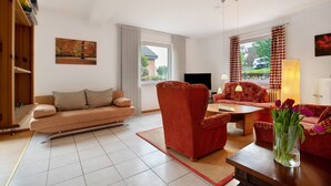 Ein Wohnzimmer mit einer Couch, einem Sessel und einem Couchtisch.
