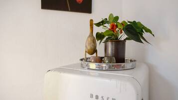 Een wit Bosch apparaat met een metalen plateau, een klein plantje en een decoratief object.