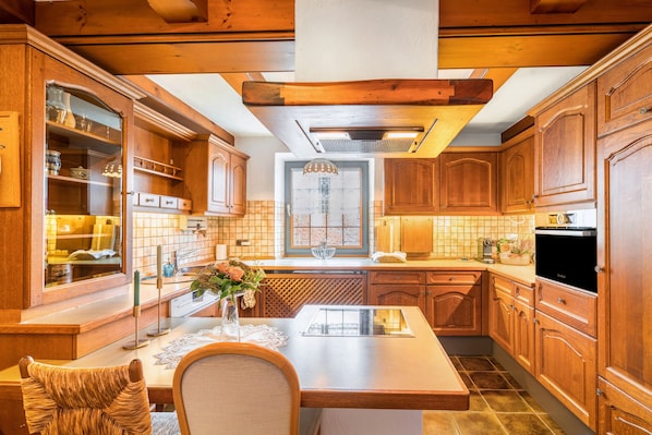 A kitchen with wooden cabinets, a central island, and a window above the sink.
