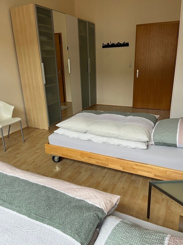 Un dormitorio con cama, una silla, un armario y una puerta.
