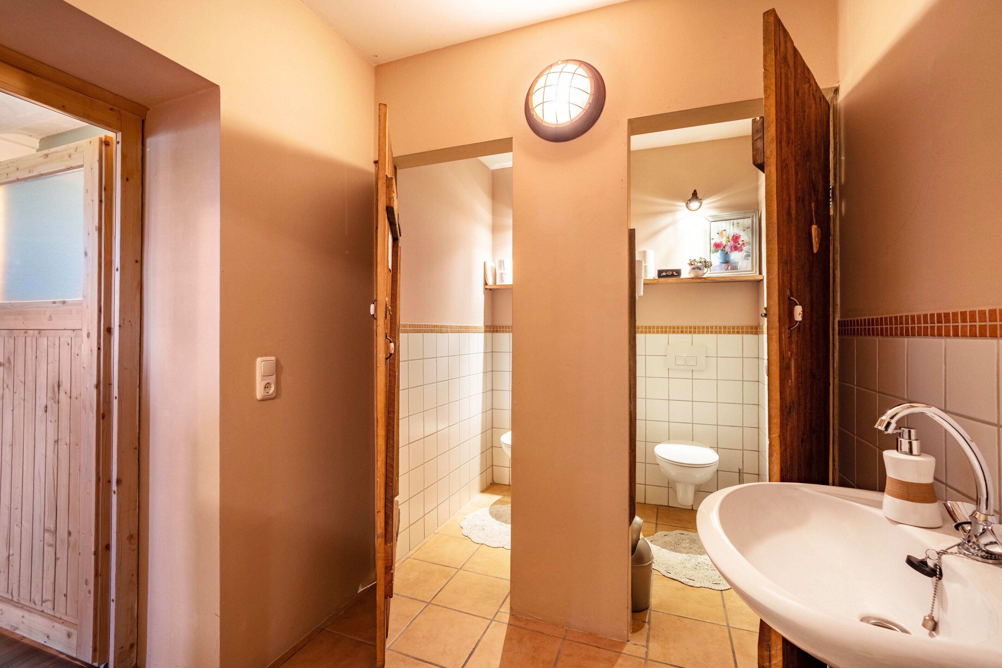 A bathroom with a sink, toilet, and shower area.