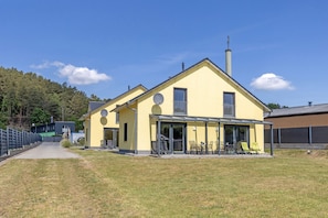 Un bâtiment jaune doté d’un patio couvert, d’une cheminée et d’une antenne parabolique.